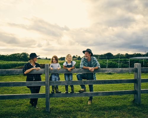 Full length shot of a family of four standing on their farm